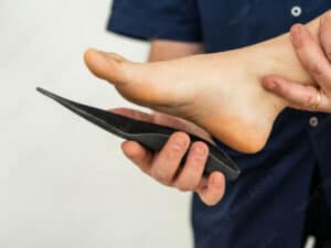 podologo fornisce plantare al paziente podologo applica plantare